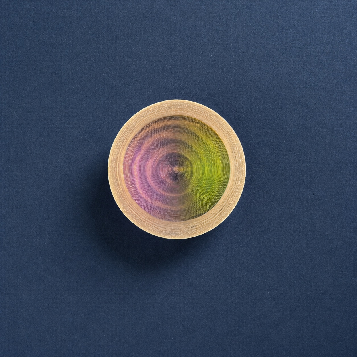 Printed vessel one seen from above, concentric toolpath rings shading pink to green